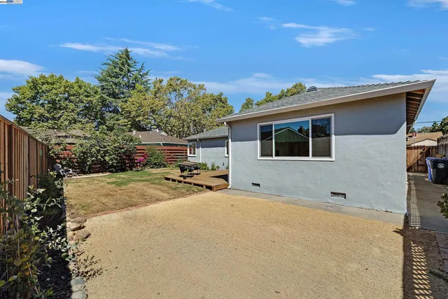 a view of a house with backyard and a tree