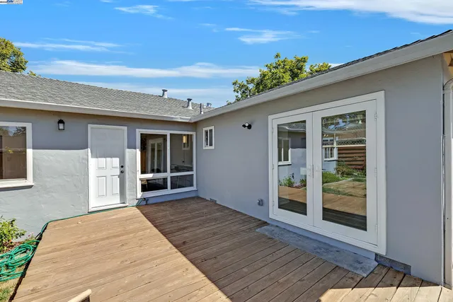 a view of a house with a wooden deck and backyard