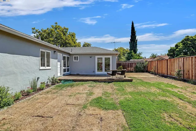 a view of a patio with table and chairs with wooden fence