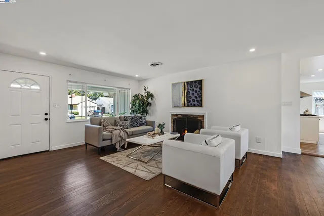 a living room with fireplace furniture and a wooden floor