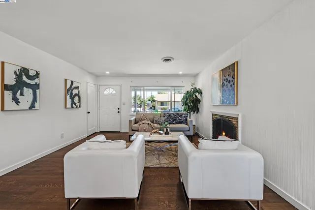 a living room with furniture a fireplace and a large window