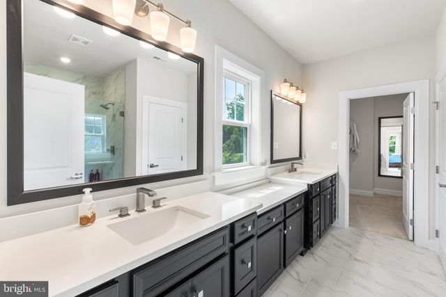 a bathroom with a double vanity sink and mirror