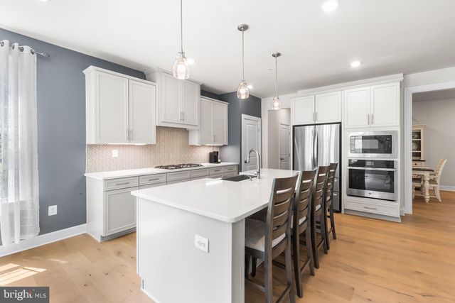 a kitchen with stainless steel appliances a stove a sink refrigerator and a wooden cabinets