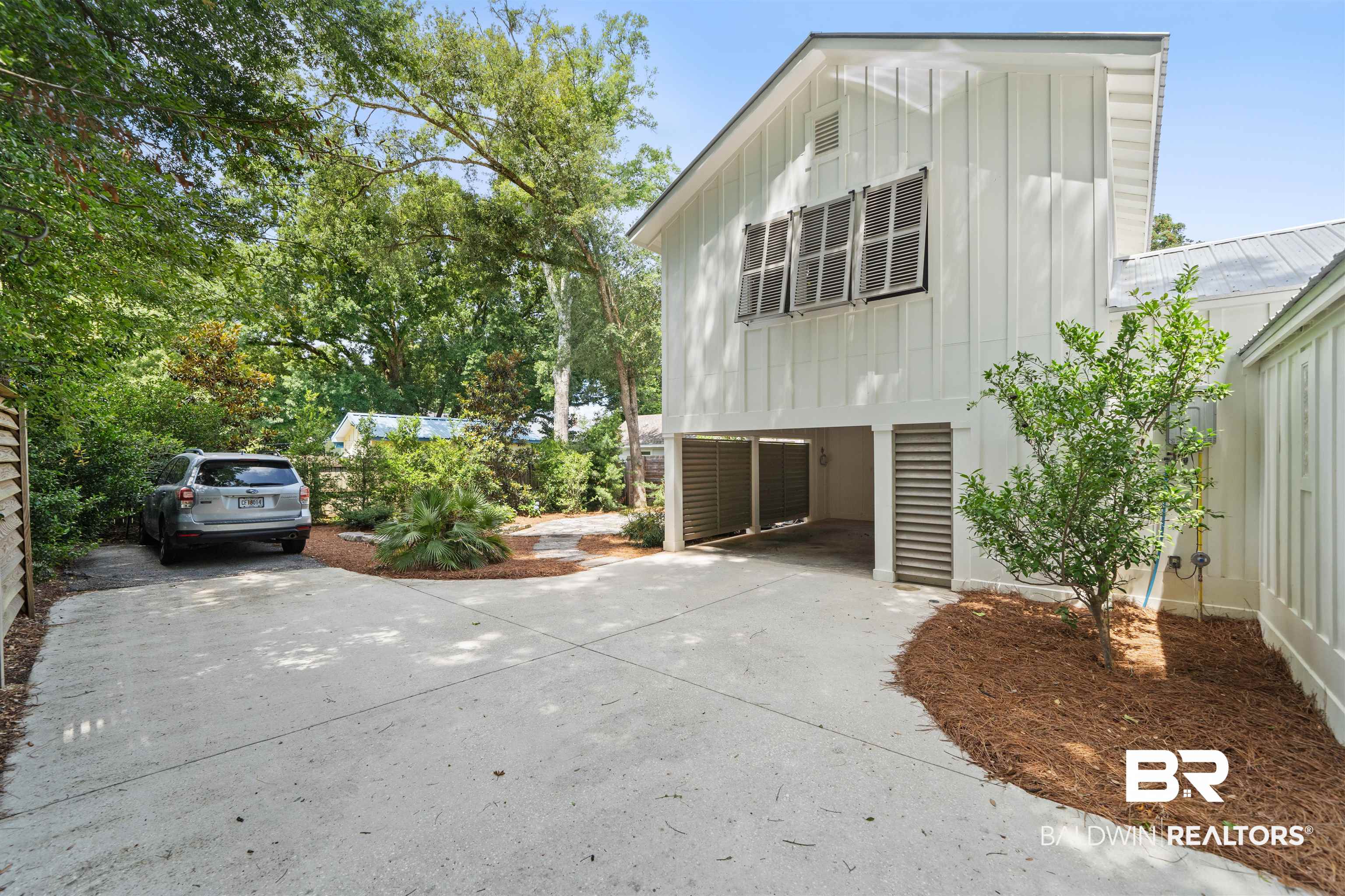 106 White Avenue Fairhope, AL 36532 - Photo 26 of 35 View of home's exterior with board and batten siding, a carport, and concrete driveway