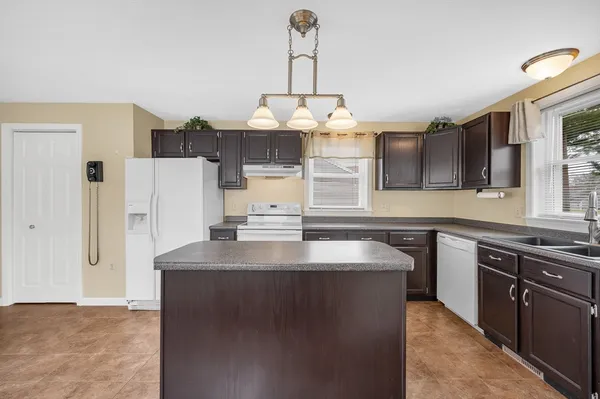a kitchen with stainless steel appliances granite countertop a sink a stove and a refrigerator