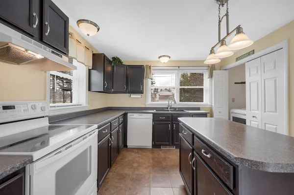 a kitchen with stainless steel appliances granite countertop a sink stove and cabinets