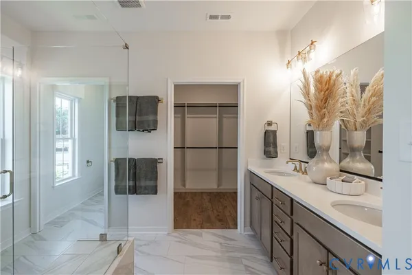 a bathroom with a double sink shower and mirror