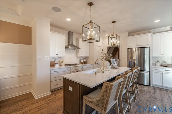 a kitchen with stainless steel appliances a dining table chairs stove refrigerator and cabinets