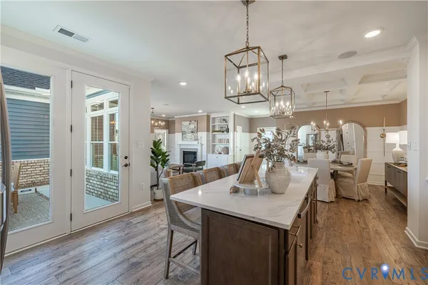 a view of a dining room and livingroom with furniture wooden floor a chandelier