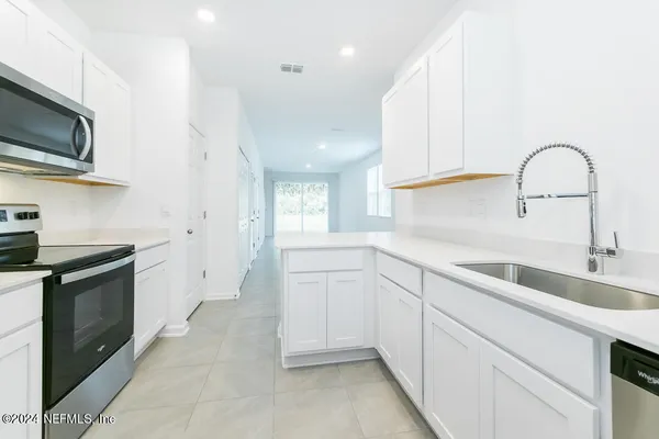 a kitchen with a sink cabinets and appliances