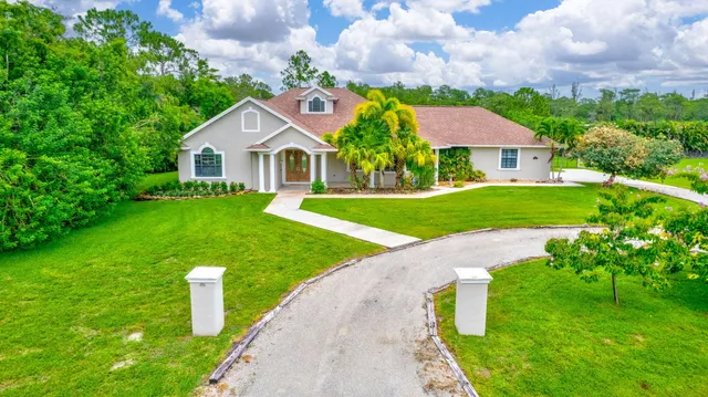 a view of house with garden and outdoor seating