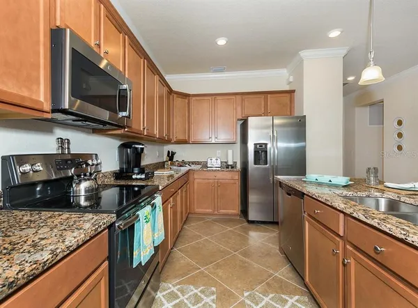 a kitchen with granite countertop a sink a counter top space stainless steel appliances and cabinets