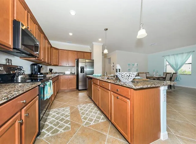 a kitchen with stainless steel appliances granite countertop a stove a sink a oven and a refrigerator
