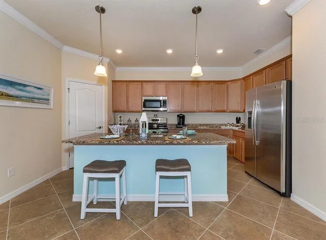 a kitchen with kitchen island granite countertop a sink counter and chairs