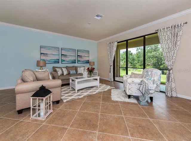 a living room with furniture and a floor to ceiling window