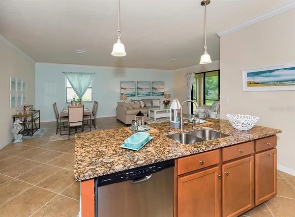 a kitchen with granite countertop a sink a stove and cabinets