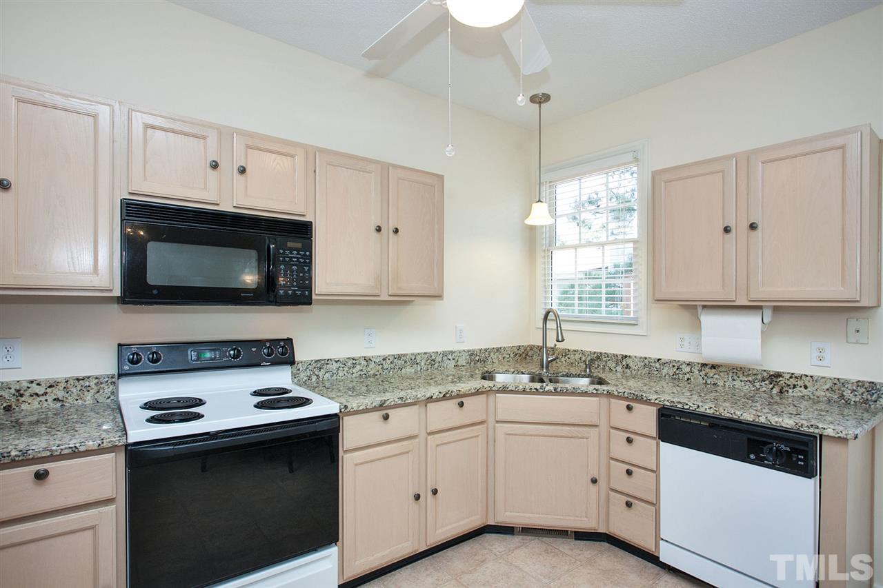 600 Hanska Way Raleigh, NC 27610 - Photo 3 of 18 a kitchen with granite countertop white cabinets and white appliances