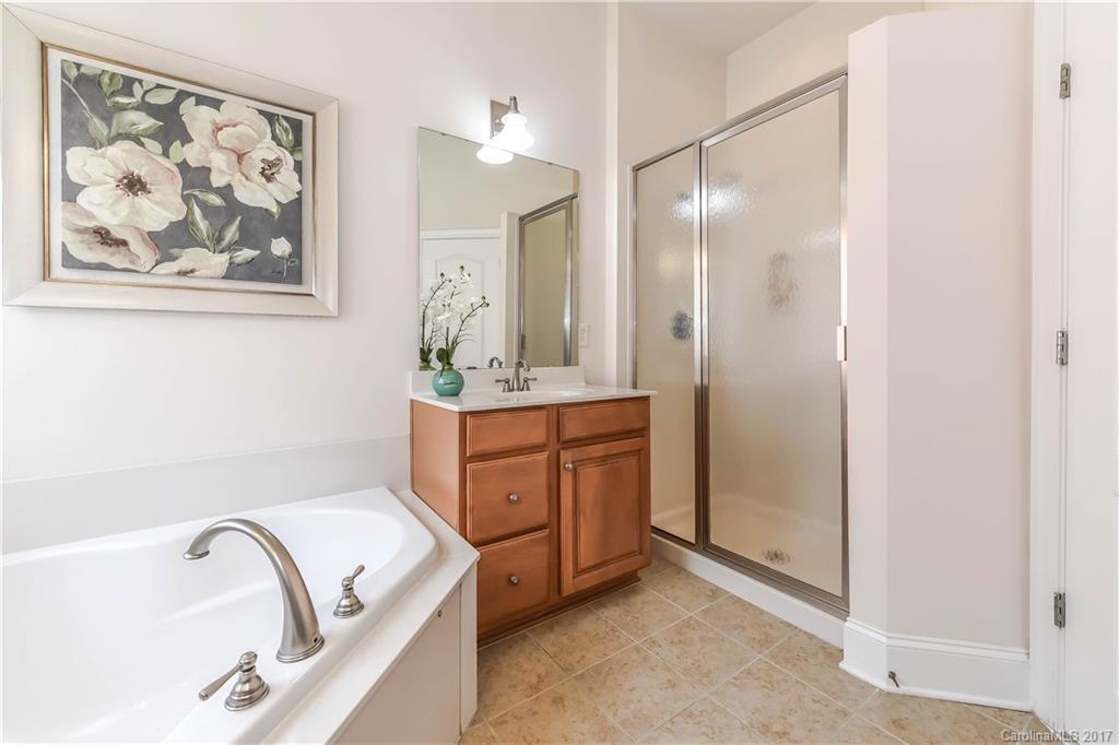 10944 Round Rock Road Charlotte, NC 28277 - Photo 18 of 23 a bathroom with a granite countertop sink a mirror and a bathtub