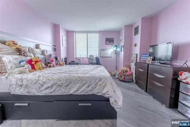 a bedroom with a bed dresser and a window