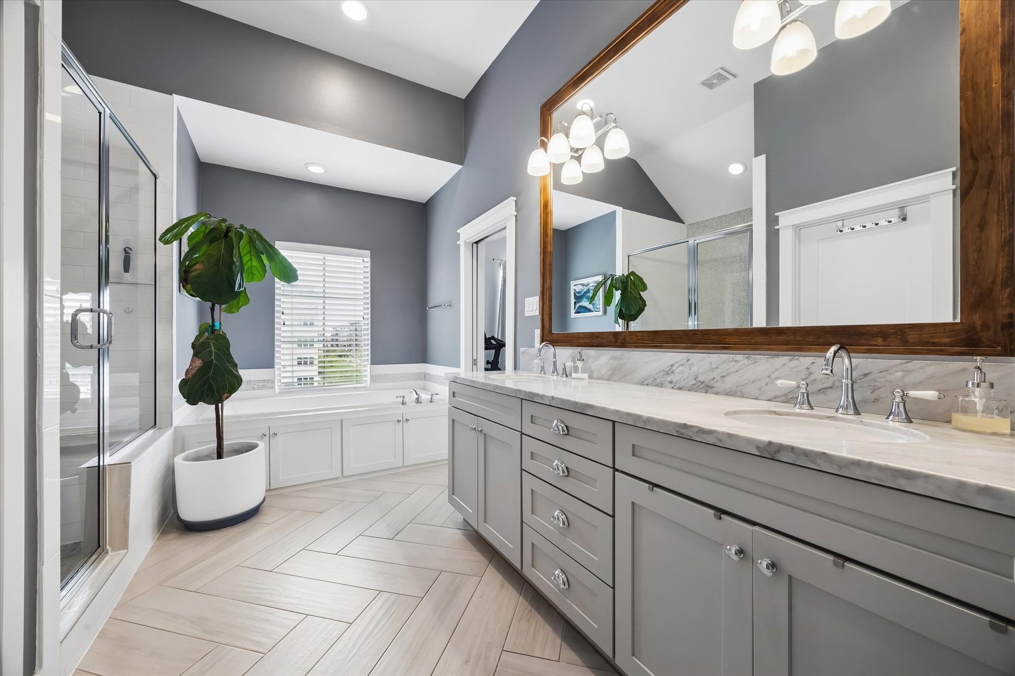 2503 Nicholson Street Houston, TX 77008 - Photo 12 of 22 Primary en-suite bath features stone-topped double vanity accented with a beautifully framed wood mirror, bringing warmth to the space. Oversized shower with bench, soaking tub, private water closet, and designer tile selections make this bathroom shine.