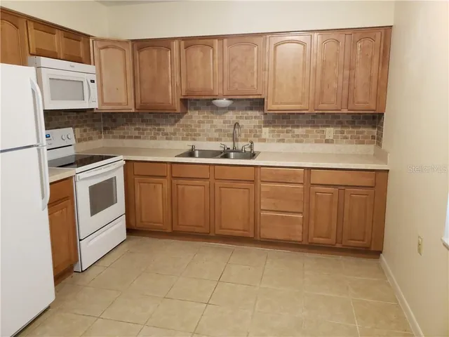 a kitchen with stainless steel appliances granite countertop a sink a stove and cabinets