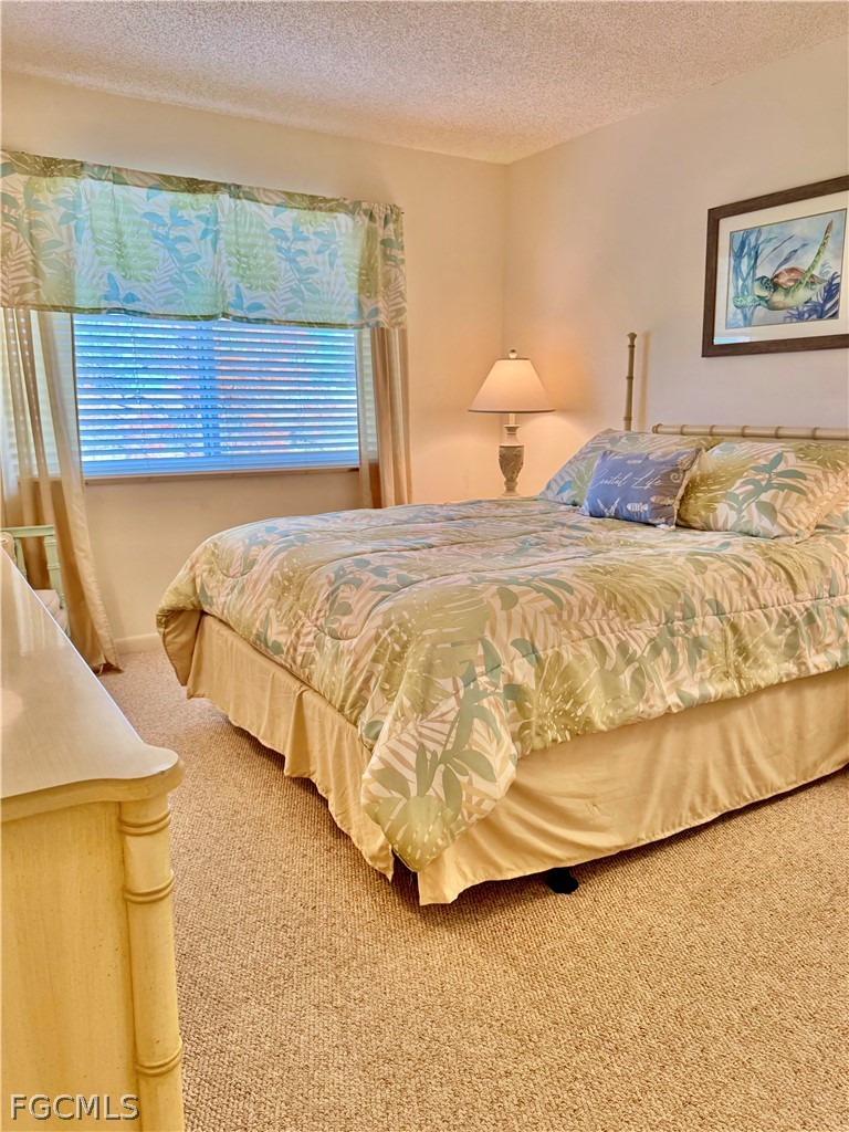 159 Quails Nest Road, Unit 2 Naples, FL 34112 - Photo 13 of 17 a bedroom with a bed and a painting on the wall