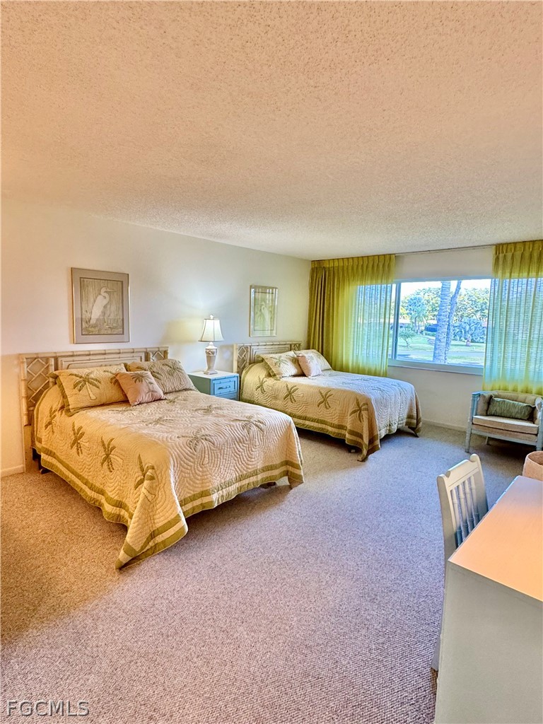 159 Quails Nest Road, Unit 2 Naples, FL 34112 - Photo 8 of 17 a spacious bedroom with two beds and a large window