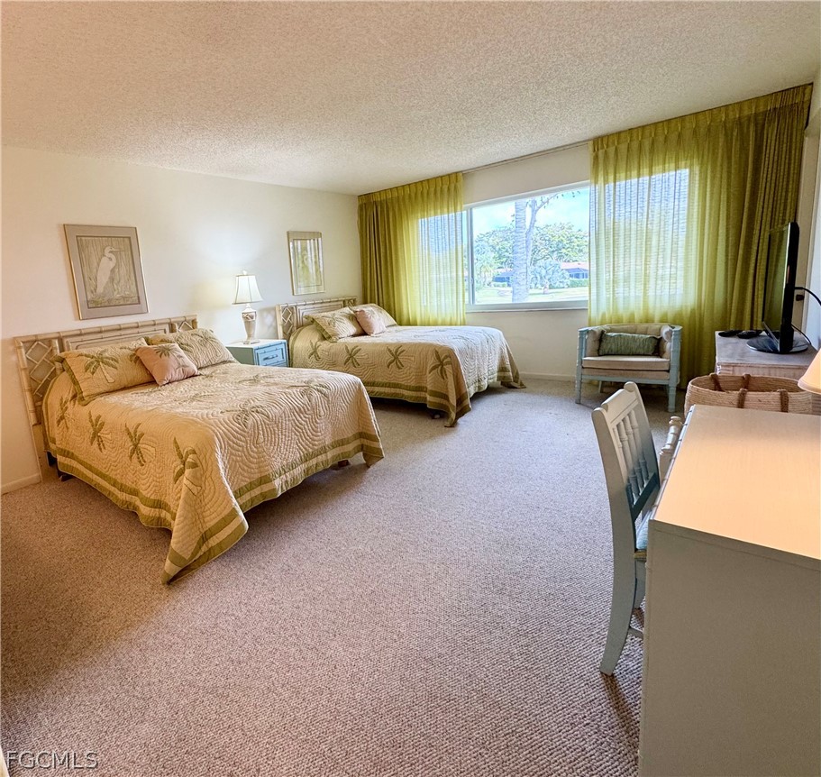 159 Quails Nest Road, Unit 2 Naples, FL 34112 - Photo 9 of 17 a bedroom with two beds and large windows