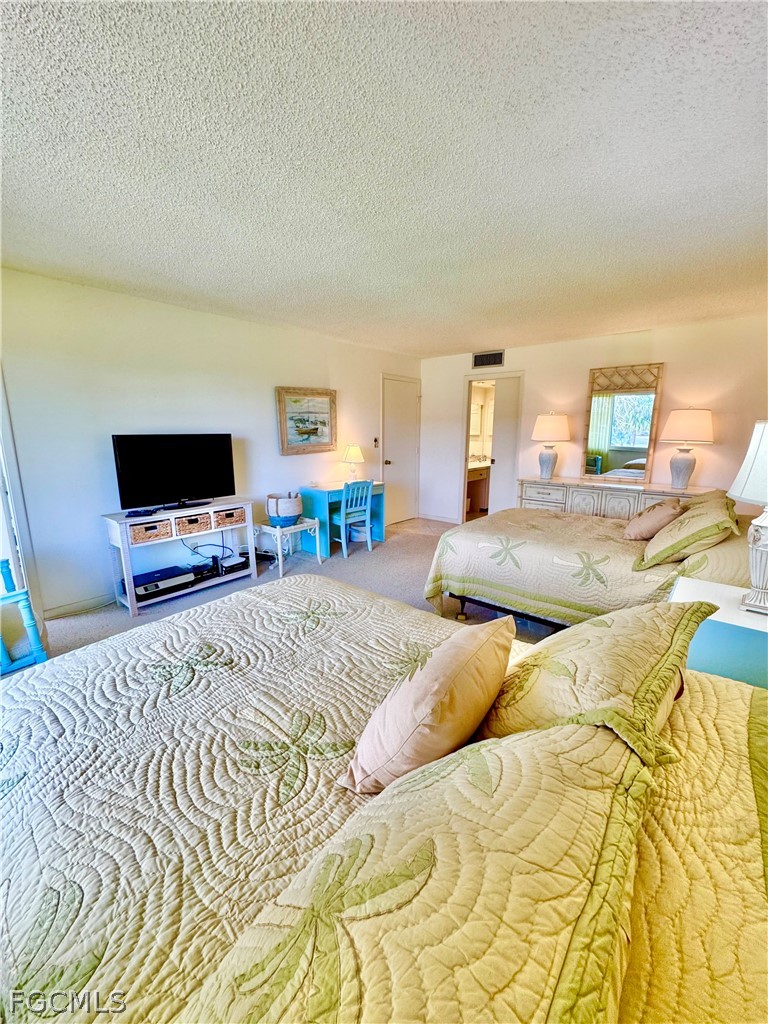 159 Quails Nest Road, Unit 2 Naples, FL 34112 - Photo 10 of 17 a bedroom with a bed and a flat screen tv