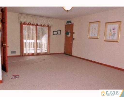 23 Butcher Road Monroe Township, NJ 08831 - Photo 3 of 7 a view of an empty room with a window