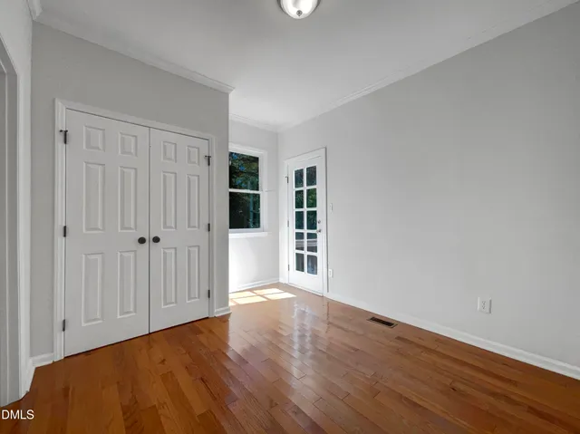 a view of an empty room with wooden floor