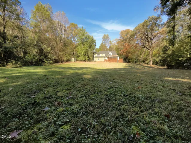 a view of a large house with a big yard and large trees