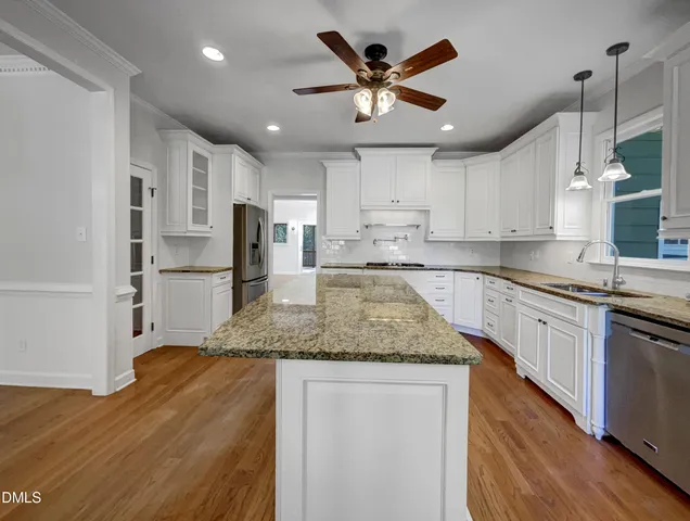 a kitchen with stainless steel appliances granite countertop a sink refrigerator and cabinets