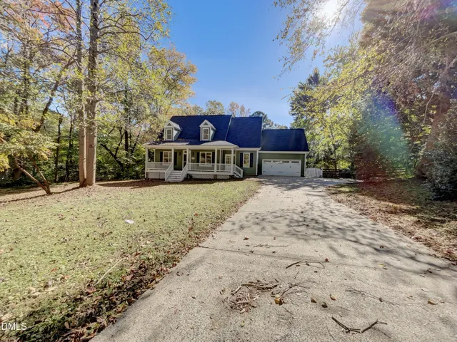a front view of a house with a yard covered with snow and trees