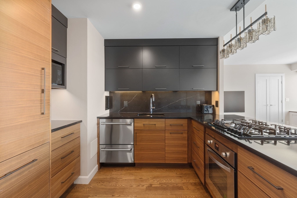 85 East India Row, Unit 38H Boston, MA 02110 - Photo 4 of 15 a kitchen with stainless steel appliances granite countertop a stove and a refrigerator