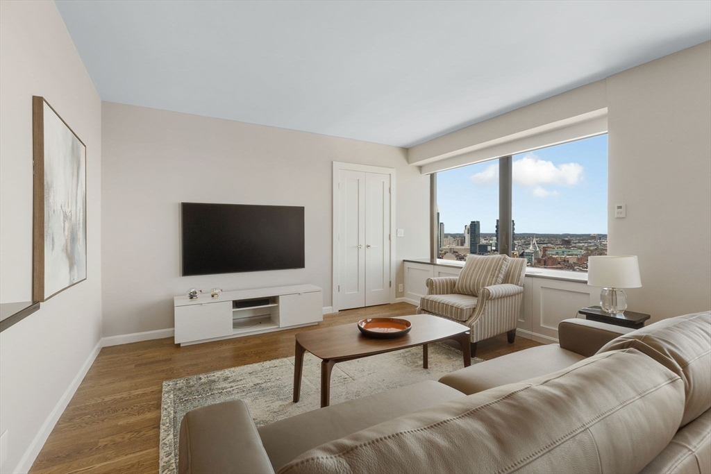 85 East India Row, Unit 38H Boston, MA 02110 - Photo 6 of 15 a living room with furniture and a flat screen tv