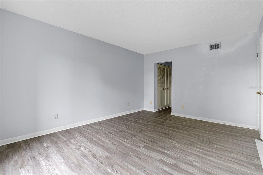 8203 Sun Spring Circle, Unit 62 Orlando, FL 32825 - Photo 11 of 19 a view of an empty room with wooden floor and a window