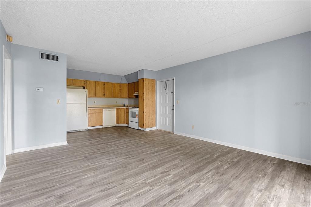 8203 Sun Spring Circle, Unit 62 Orlando, FL 32825 - Photo 4 of 19 a view of empty room with wooden floor and kitchen