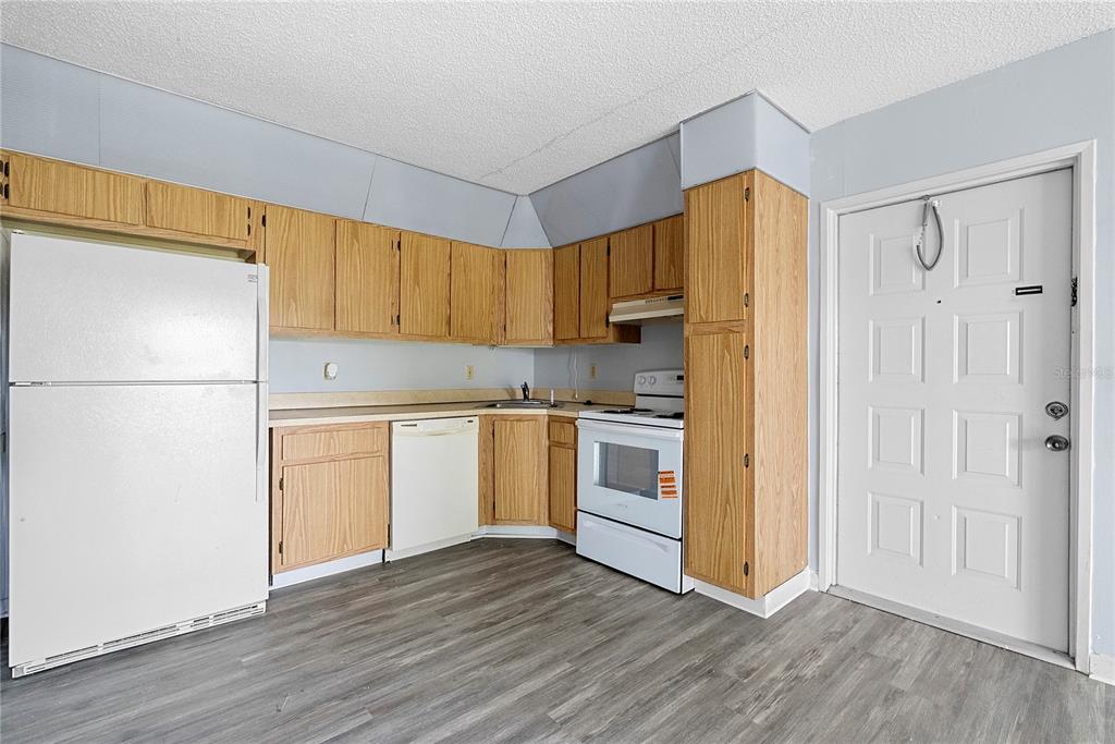 8203 Sun Spring Circle, Unit 62 Orlando, FL 32825 - Photo 7 of 19 a kitchen with a sink a refrigerator and white cabinets