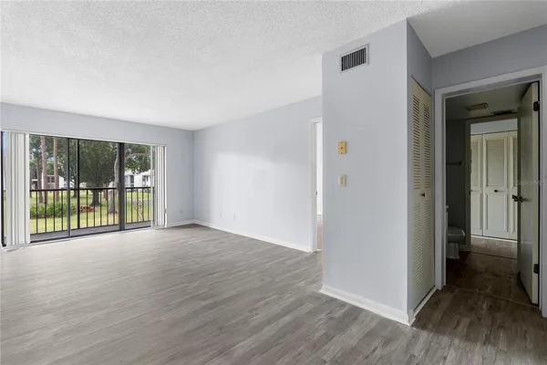 a view of a room with wooden floor and a window