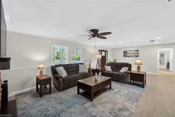 a living room with furniture and view of kitchen