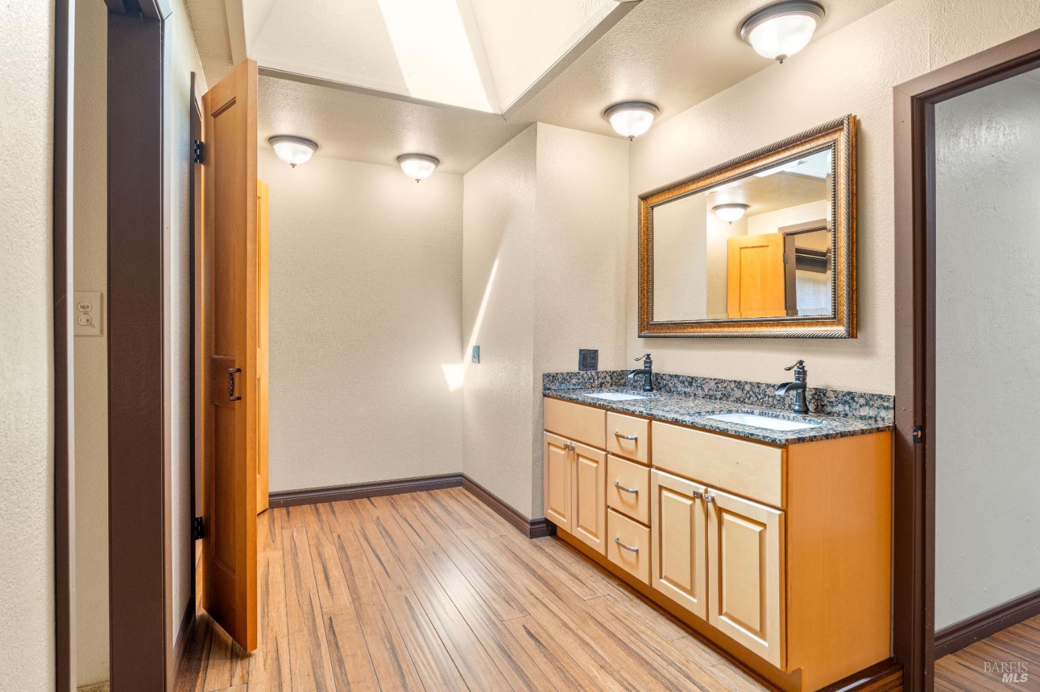 888 Watson Road Ukiah, CA 95482 - Photo 13 of 39 a bathroom with granite countertop a sink and a wooden floor