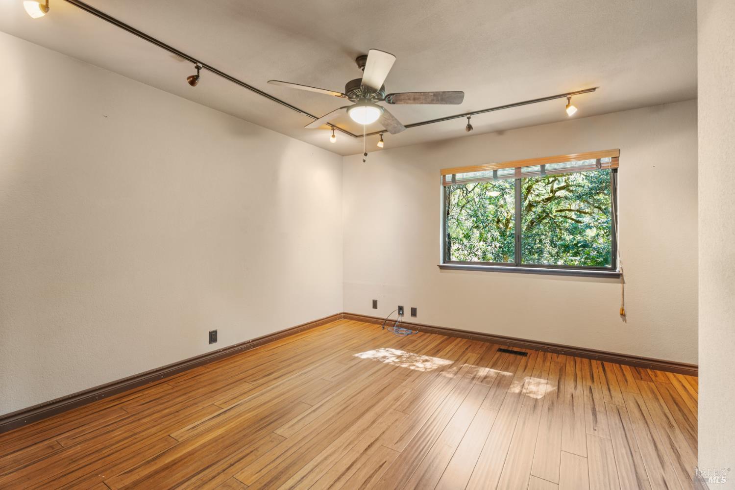 888 Watson Road Ukiah, CA 95482 - Photo 20 of 39 an empty room with wooden floor chandelier fan and windows