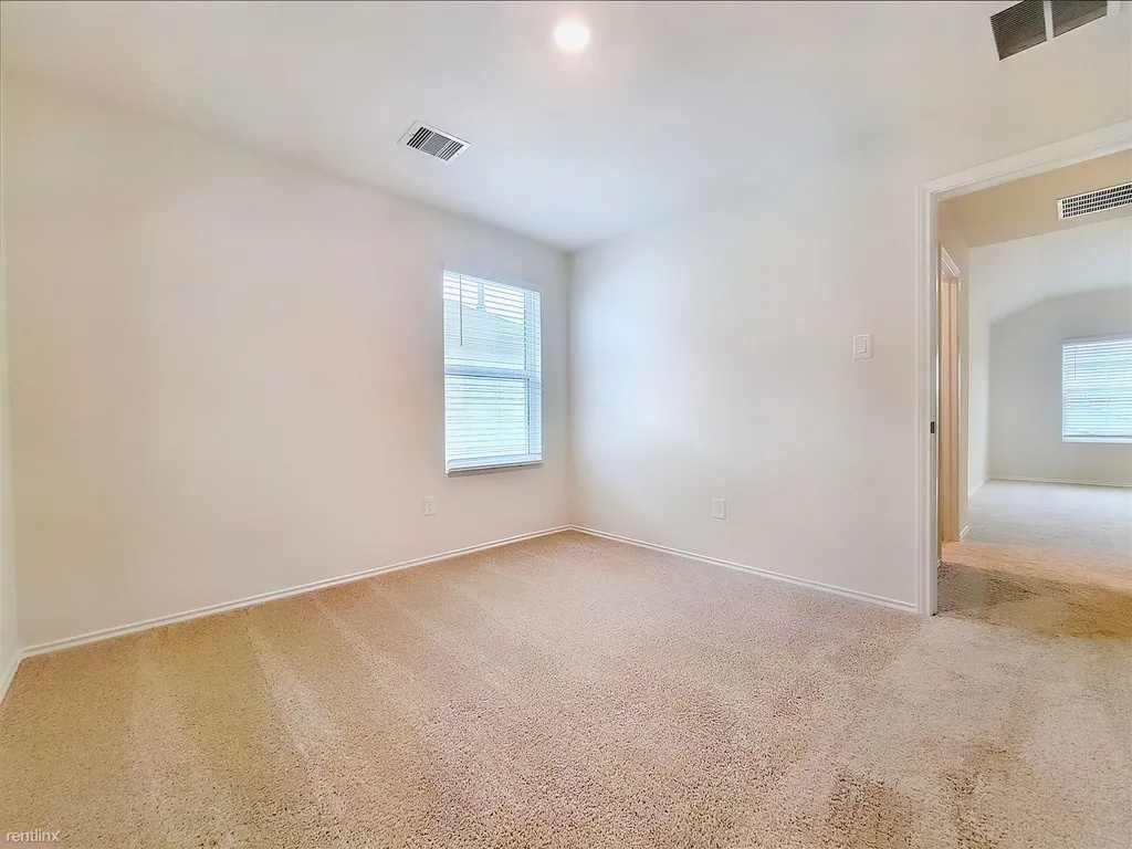419 Sickle Loop Kyle, TX 78640 - Photo 27 of 35 A well-lit room offers comfortable carpet flooring and natural light through its window.