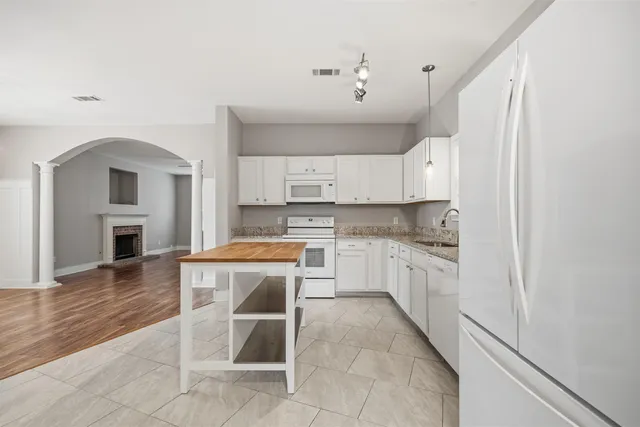 a kitchen with cabinets and wooden floor