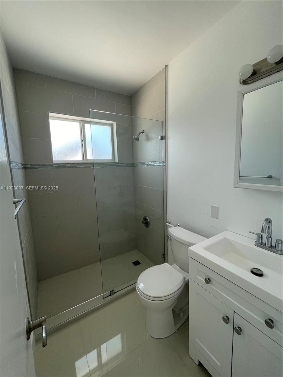8215 Crespi Boulevard, Unit 4 Miami Beach, FL 33141 - Photo 16 of 34 a bathroom with a sink a toilet and shower