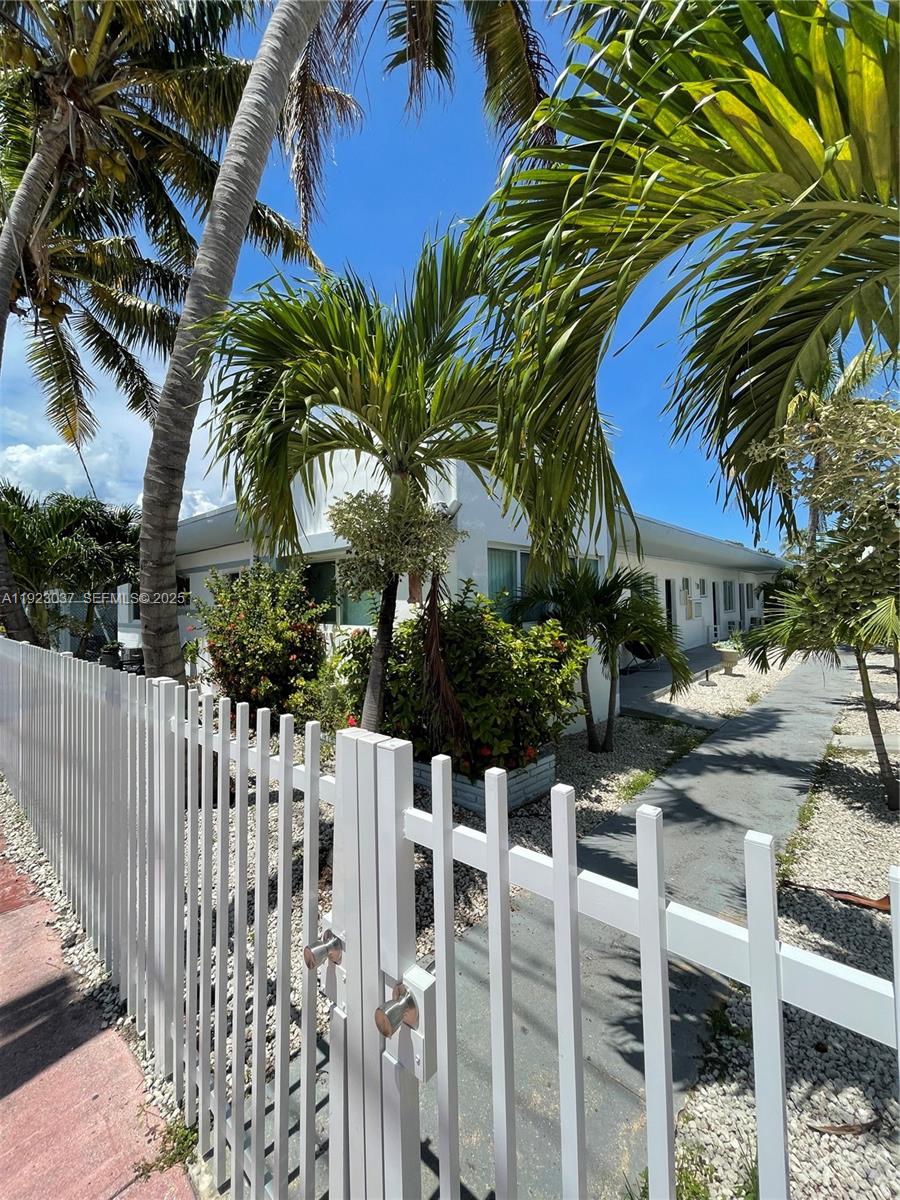8215 Crespi Boulevard, Unit 4 Miami Beach, FL 33141 - Photo 2 of 34 a couple of table and chairs in front of yellow house
