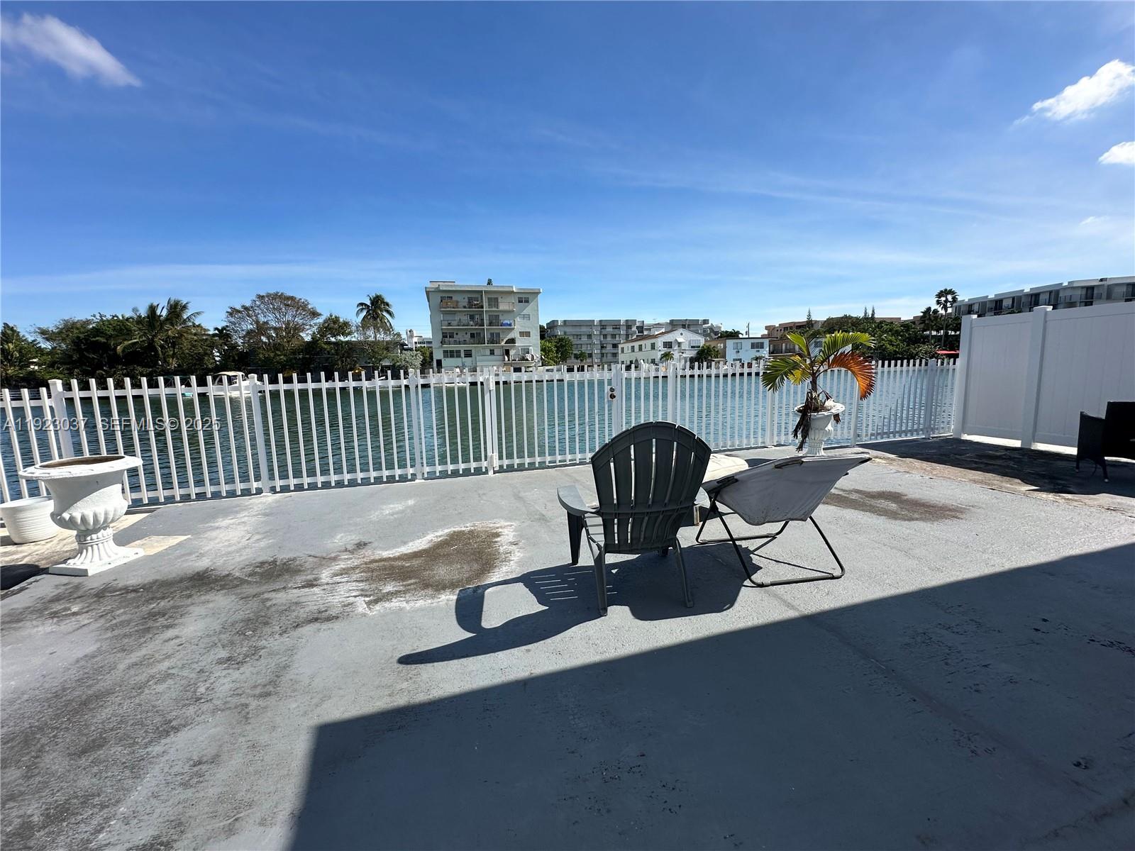 8215 Crespi Boulevard, Unit 4 Miami Beach, FL 33141 - Photo 31 of 34 a view of a roof deck with table and chairs a fire pit and ocean view