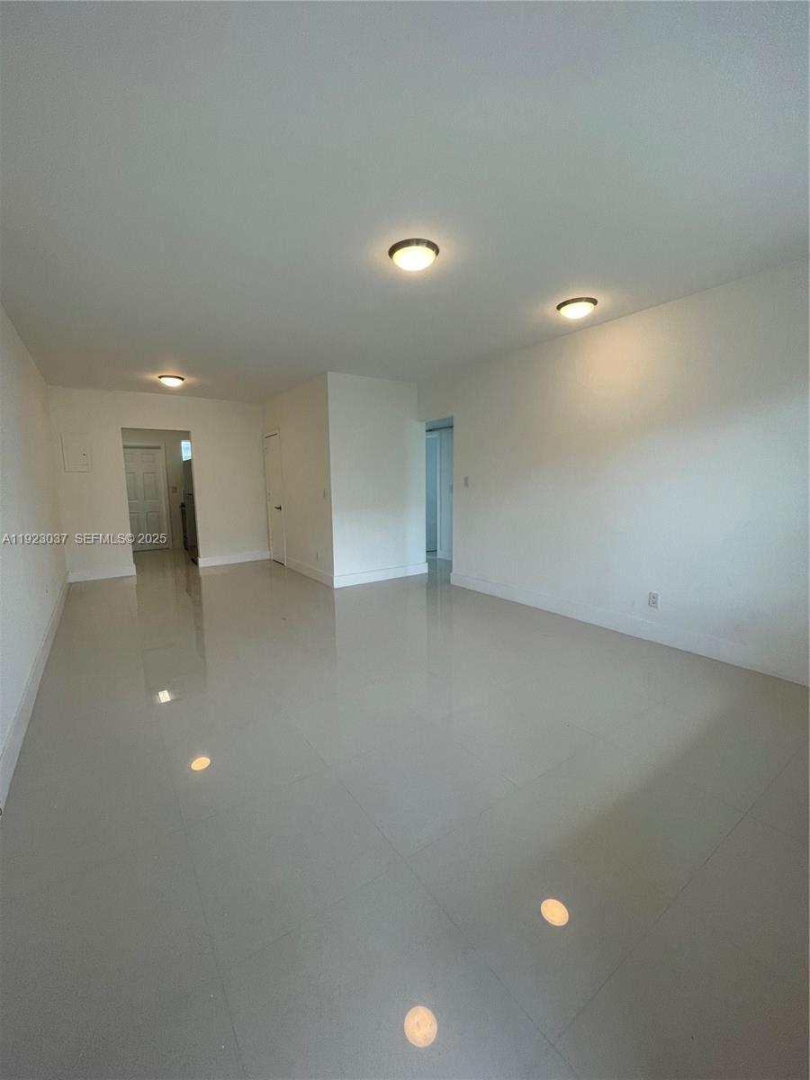 8215 Crespi Boulevard, Unit 4 Miami Beach, FL 33141 - Photo 5 of 34 wooden floor in an empty room with a window