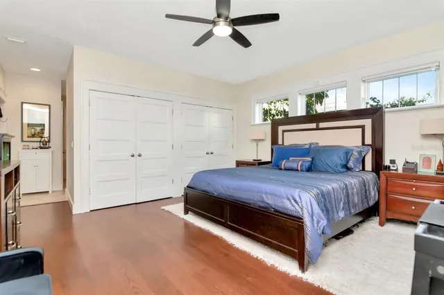 a spacious bedroom with a bed and a flat tv screen